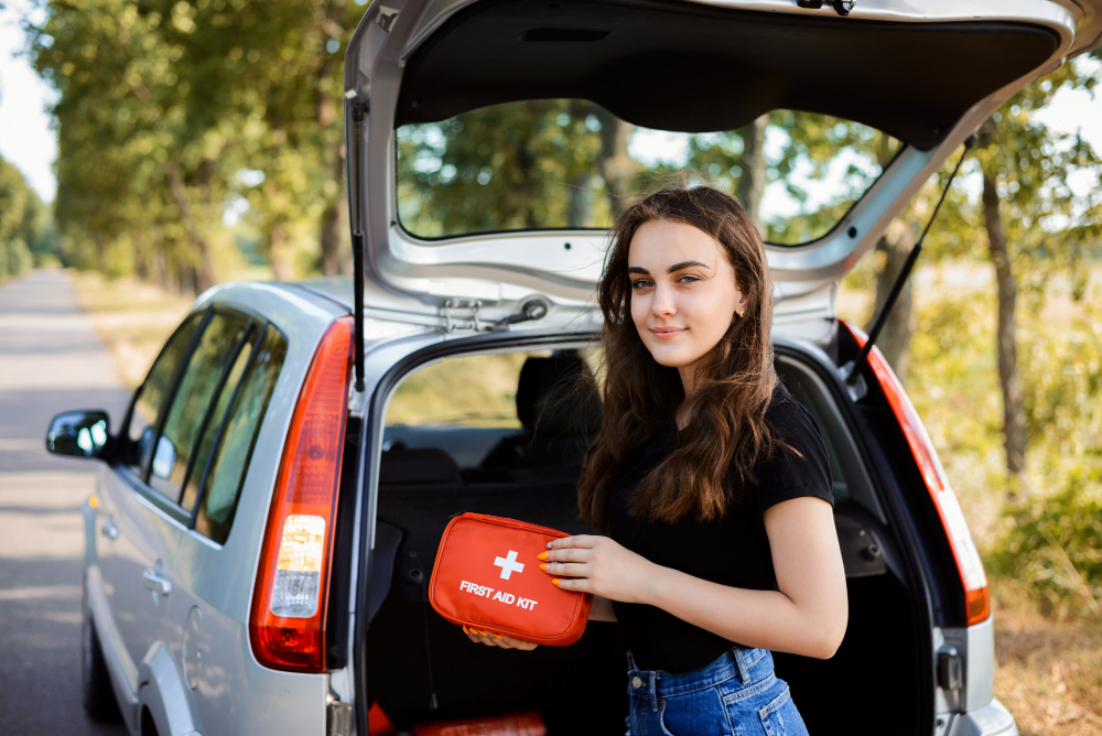 Car first aid kit: Girl holding a first aid kit in the car